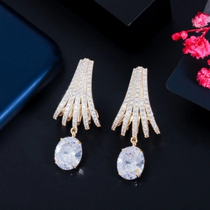 Detail of luxury gold earrings featuring white zircon pavé and large oval center stones