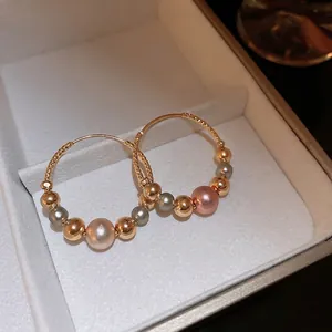 Elegant gold twisted hoop earrings with multi-colored pearls and textured beads