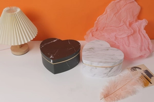 Detail of heart-shaped marble gift boxes in black and white with elegant gold line accents
