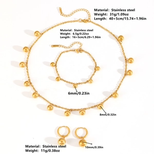 Gold stainless steel ball pendant jewelry set with necklace, bracelet, and earrings on white