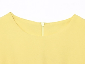 Détail de l'encolure d'une robe en mousseline jaune avec fermeture éclair invisible au dos