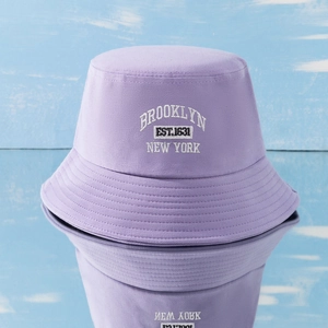 Purple cotton fisherman hat with Brooklyn embroidery shown on a blue wooden background