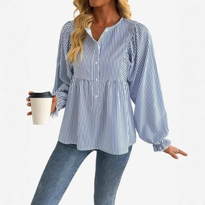 Detail der blau gestreiften Bluse mit Puffärmeln und Rüschenbündchen am Damenmodel