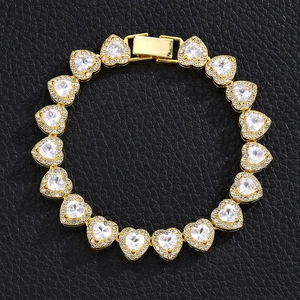 Dettaglio ravvicinato del bracciale a maglie a cuore dorate con zirconi lucidi su pelle nera