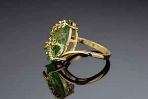 Macro di anello a libellula dorata con gemma marquise verde oliva e motivi a foglia
