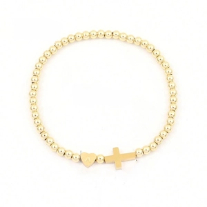 Gold beaded heart and cross bracelet with letter A pendant on a white background