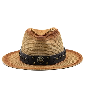 Detail of gradient woven straw hat with black leather band and metal horseshoe emblem