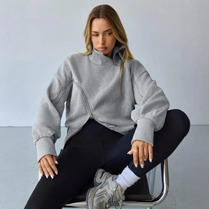 Detail of gray turtleneck sweatshirt featuring unique asymmetric zipper and ribbed cuffs