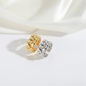 Detailed view of gold and silver heart-shaped chain rings on white silk fabric background