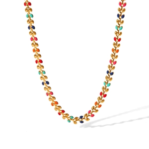 Detail of gold-tone necklace with colorful enamel leaf links in red, orange, and blue