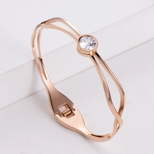 Rose gold titanium steel bracelet with a single round zircon on a white platform