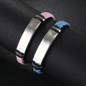 Detail of pink and blue braided leather bracelets with polished silver metal nameplates