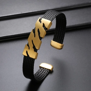 Détail macro du bracelet étoile pour homme avec finition dorée brossée et tresse noire
