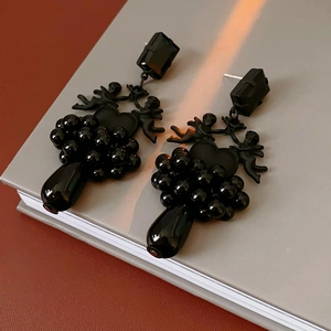 Detailed shot of black vintage angel heart earrings with onyx beads on a book