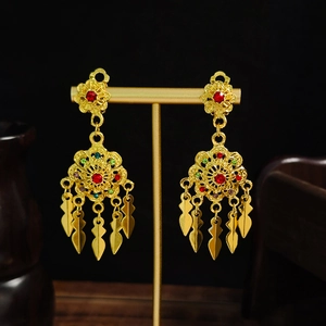 Detailed view of bohemian gold hollow flower earrings with colorful rhinestones on black stand