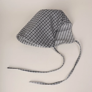 Detail of baby sun hat featuring black gingham pattern and striped lining with long straps