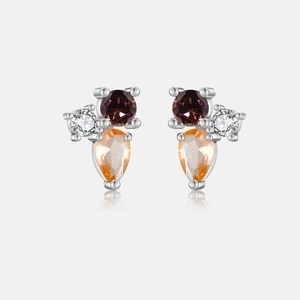 Macro shot of silver stud earrings with pear-cut champagne stones and clear crystals