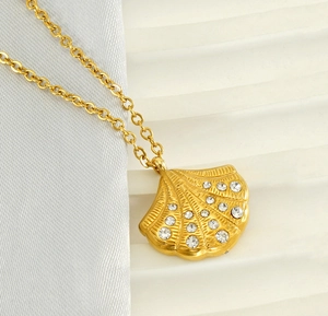 Macro detail of 18K gold-plated shell pendant featuring sparkling pave set white zircons