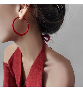 Close-up of minimalist red hoop earrings on model featuring a matte finish and chic style
