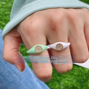 Close-up of mint green and white enamel copper rings with micro-pave round zircons