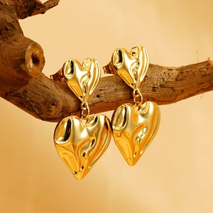 Boucles d'oreilles double cœur plaquées or 18K avec texture martelée sur une branche