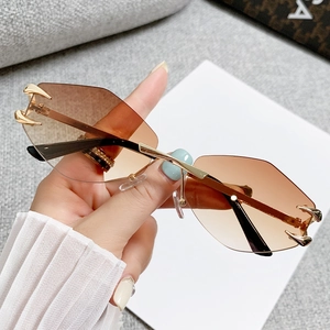Modern rimless polygon sunglasses with gradient brown lenses and golden metal claw accents