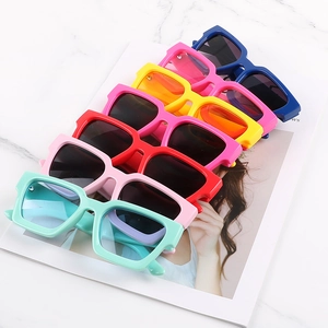 Flat lay of colorful thick-frame square sunglasses stacked on a magazine cover