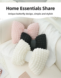 Detail of bow-shaped pillows made from textured popcorn fabric in pink, black, and beige