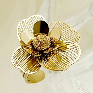 Macro detail of golden flower ring showing hollow petals and textured metal stamen