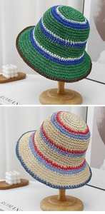Detail of colorful striped hand-woven straw bucket hats on minimalist wooden stands