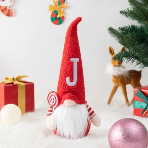 Three red Christmas gnomes with JOY letters on plush fur with festive decorations