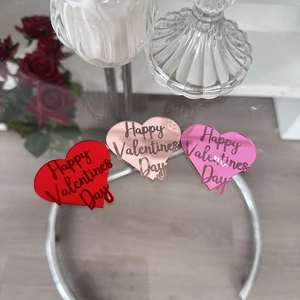 Three acrylic heart cupcake toppers in red, rose gold and pink for Valentine decorations