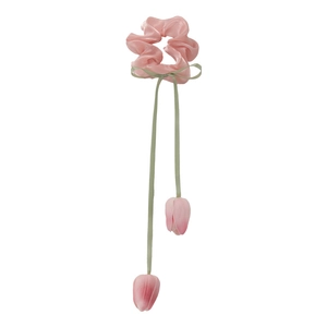Pink tulip flower hair scrunchie with green ribbon tassels on white studio background