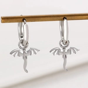 Detail of silver dragon wing earrings with long tail pendants on a metal display stand