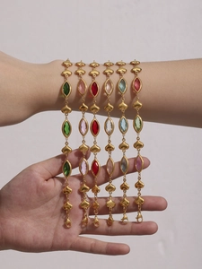 Close-up of stacked colorful heart bracelets with Czech glass and gold-plated links