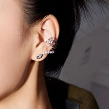 Detailed view of silver snake ear cuff with sparkling zircon stones on an ear