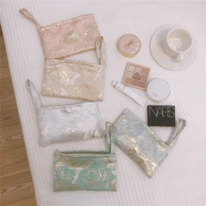 Close-up of five colorful rose jacquard mini bags with elegant metallic floral patterns