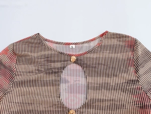 Détail du col rond taille S avec découpe goutte et bouton doré sur robe en maille rayée
