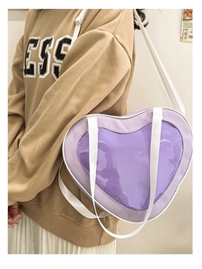 Detail of purple heart-shaped bag with transparent PVC window and white shoulder strap