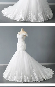 Détail de la broderie en dentelle aux épaules nues et de la traîne en tulle de la robe