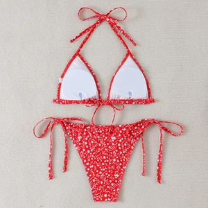 Detail of red floral bikini with removable pads and textured fabric on woven mat