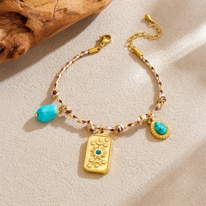 Bohemian braided bracelet with sun relief pendant and turquoise stones on beige background