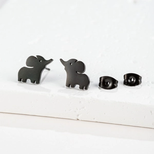 Macro shot of cute black elephant stud earrings with butterfly backs on white stone
