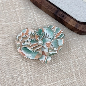 Detailed view of acetate orchid hair clip with marble texture and center pearl