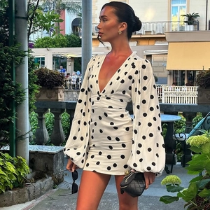 Dettagli dello scollo a V e della fantasia a pois su un elegante abito a maniche a campana