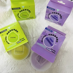 Macro detail of tear-drop makeup sponges in green and purple with clear storage cases