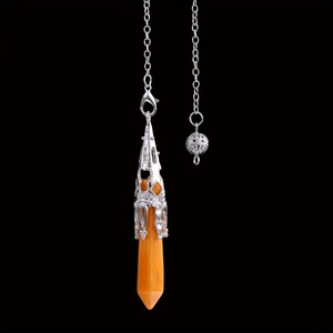 Detailed macro shot of an orange crystal hexagonal pendulum with intricate silver floral cap