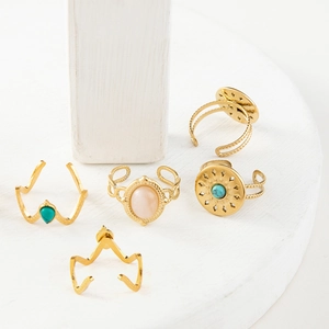Detail of five vintage gold stainless steel rings set with turquoise and moonstone