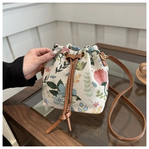 Detailed close-up of floral fabric bucket bag with premium brown leather drawstring