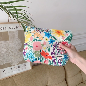 Close-up of floral print fabric makeup bag featuring the Sozakka woven brand label